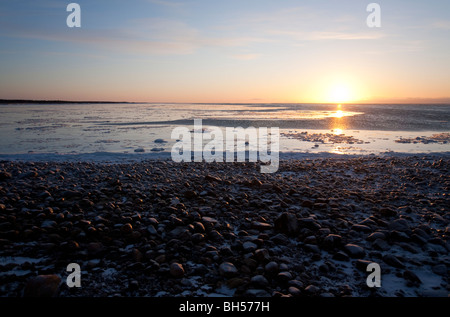 Il Ghiaccio coperto le rocce in riva al tramonto , Finlandia Foto Stock