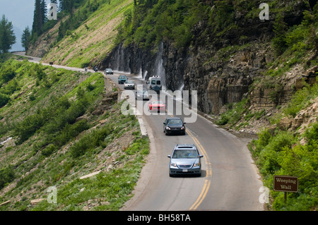 Veicoli, incluso un bus rosso" per andare a Sun road passano attraverso la cascata conosciuta come 'piangendo Wall' Foto Stock