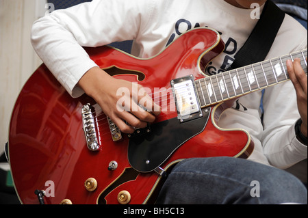 Ragazzo giocare con un aria di chitarra jazz, stile Gibson 335 Foto Stock