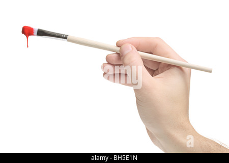 Una mano che tiene un pennello con vernice rossa su di esso Foto Stock