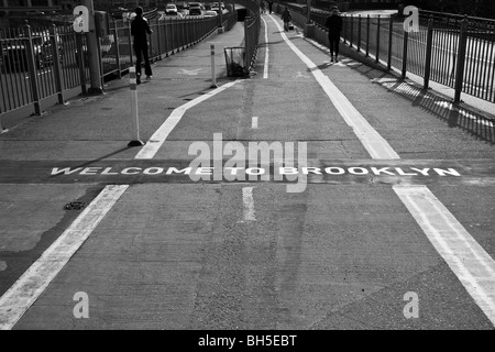 Una versione monocromatica del messaggio di benvenuto intarsiato in terra sul lato Brooklyn del Ponte di Brooklyn a New York Foto Stock