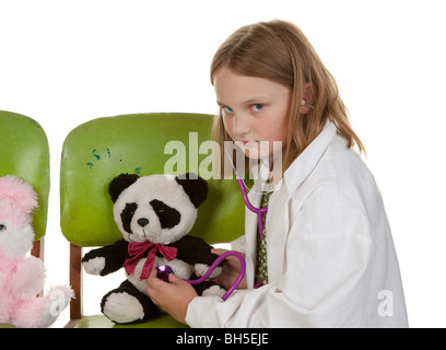 Ragazza giovane medico a giocare con il suo peluche assomiglia a cattive notizie Foto Stock