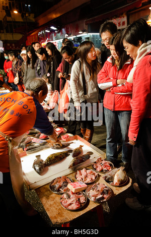 People shopping a Hong Kong di Bowrington Road mercato umido di notte. Foto Stock