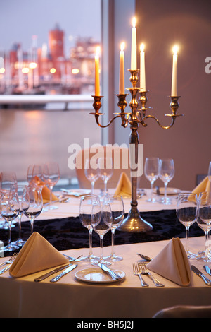 Tabella a lume di candela in impostazione St Davids Hotel, Cardiff, Galles,guardando fuori attraverso la baia verso l'edificio pierhead. Foto Stock