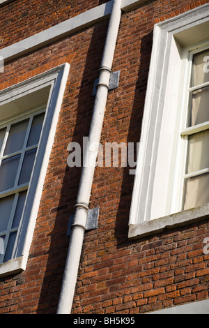 Un vecchio filo tubo di scarico / tubo verso il basso sulla parete di mattoni a Ham Casa nel Surrey. Foto Stock