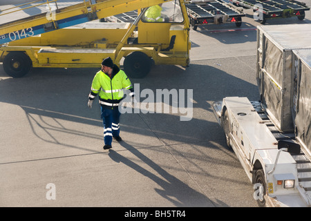 In materia di aviazione. Personale di terra presso l'Aeroporto Internazionale di Francoforte fra Lufthansa di movimentazione bagagli bagaglio ai contenitori di carico. Foto Stock