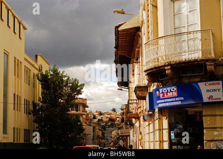 Ecuador Cuenca, anteriore di un negozio che vende articoli di fotografia, in una casa costruita con architettura coloniale, una lunga strada con auto Foto Stock