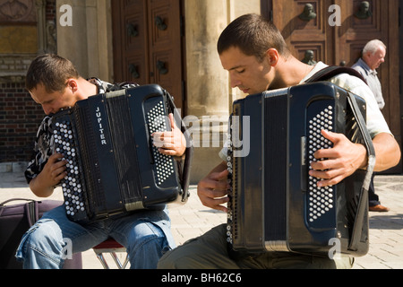 Buskers a suonare la fisarmonica all'esterno St Marys Basilica. Piazza principale, Cracovia. La Polonia. Foto Stock