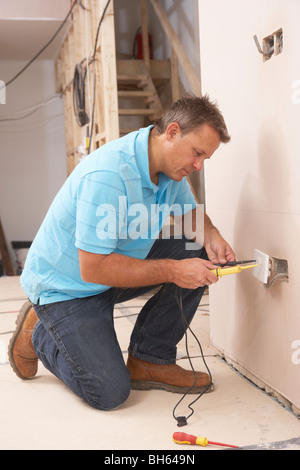 Elettricista Installazione presa di corrente a muro Foto Stock