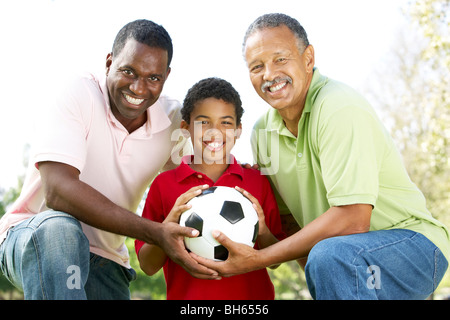 Nonno con figlio e nipote nel parco con il calcio Foto Stock