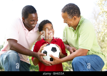 Nonno con figlio e nipote nel parco con il calcio Foto Stock