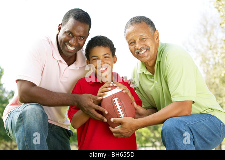 Nonno con figlio e nipote in posizione di parcheggio con il football americano Foto Stock