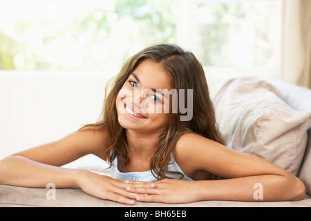 Giovane ragazza rilassante sul divano di casa Foto Stock