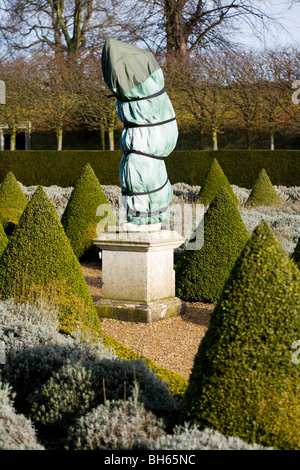 Statua avvolto per la protezione dal gelo, nel giardino formale al lato est della casa di prosciutto. Ham Casa, Surrey. Regno Unito. Foto Stock