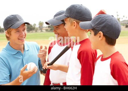 Ragazzi in squadra di baseball con pullman Foto Stock