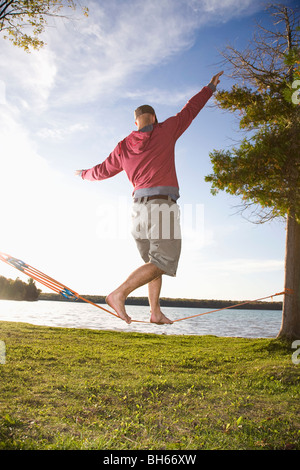 Uomo in equilibrio su slackline Foto Stock