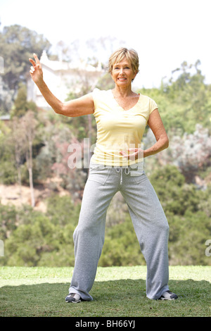 Senior donna esercita in posizione di parcheggio Foto Stock