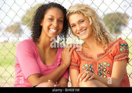 Le ragazze adolescenti seduti insieme nel parco giochi Foto Stock