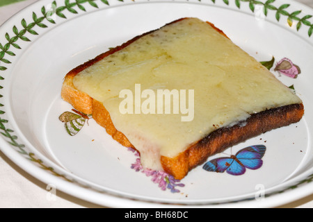 Il formaggio su pane tostato. Fuso formaggio gruviera su un pezzo di pane bianco tostato. Foto Stock