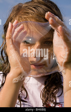 Ragazza giovane rendendo le bolle Foto Stock