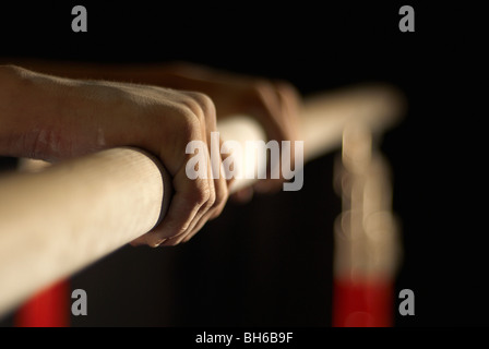 Ginnasta con le mani in mano afferrando un bar Foto Stock