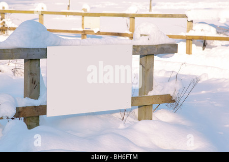 Un vuoto segno bianco in un recinto dopo il recente la caduta di neve, aggiungi il tuo messaggio. Foto Stock