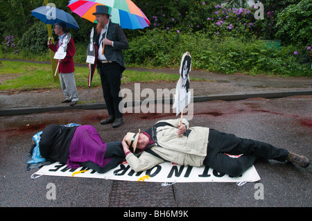 Wedding 'Die-NELL' contro la guerra in Afganistan al quartier generale della NATO. Manifestanti giacciono su strada in die-in con cartelli naming morti tra i civili Foto Stock