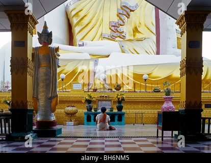 Donna seduta e pregando di fronte Kyaik Pun Paya - Quattro Budda seduto santuario MYANMAR Birmania Foto Stock