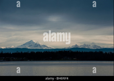 Mt. Baker e il 'Sisters' come visto da Hales passano su Lummi Island, Stati Uniti di Washington. Mt. Baker è parte del North Cascades. Foto Stock