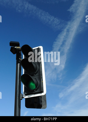 Semaforo impostato su verde con drammatica blue sky con jet contrails dietro Foto Stock