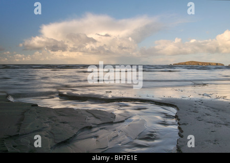 Riflessi di rosa le nuvole di neve in sabbia, Poppit Sands Beach, St Dogmaels, Pembrokeshire, Wales, Regno Unito Foto Stock