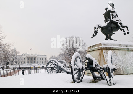 WASHINGTON DC, Stati Uniti d'America - una statua del presidente Andrew Jackson, circondato da cannoni, a Lafayette Park coperto di neve fresca. Sullo sfondo a sinistra del telaio, è la Casa Bianca. Con questa statua nel centro del parco, è utilizzato per essere noto come Jackson Park. Foto Stock