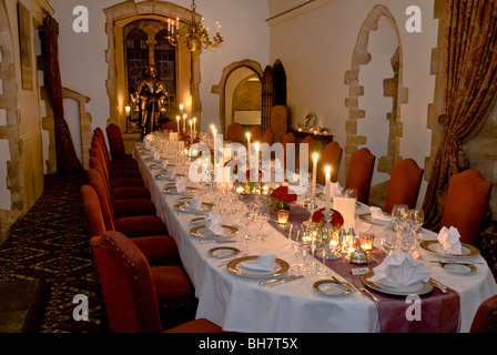 Cena a lume di candela di Natale, banchetto, atmosfera di lusso, posti a sedere formale e tavolo per cena a base di candele illuminate preparato in un ambiente di lusso Foto Stock