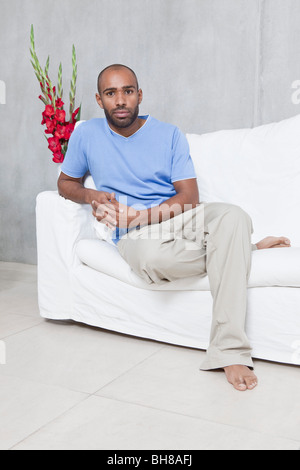 Un uomo seduto su un divano, ritratto Foto Stock