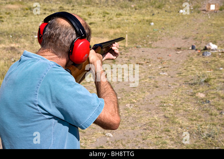 Uomo che indossa le cuffie di protezione e la ripresa di un coachgun. Foto Stock
