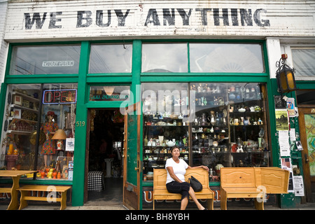 Signora seduta al di fuori di un vecchio negozio 'abbiamo comprare nulla' Missoula, Montana, USA Foto Stock
