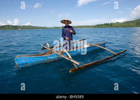 Pescatore sulla barca Outrigger, Lembeh strait, Sulawesi, Indonesia Foto Stock