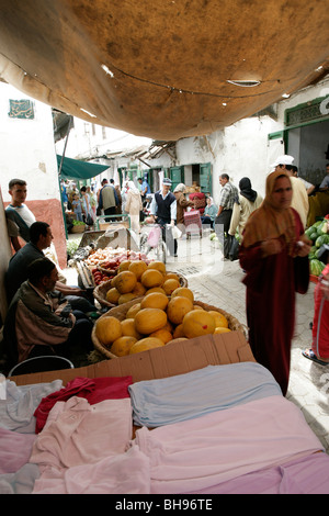 Frutta e abbigliamento per la vendita in una fase di stallo lungo uno dei molti alleati strette alla casbah in Tetuon, Marocco Foto Stock