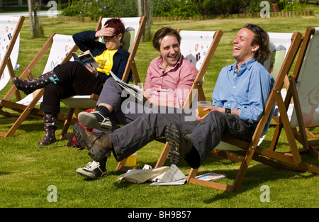 Persone di bere e la lettura prenota sat in sedie a sdraio fuori nel sole a Hay Festival 2009. Foto Stock