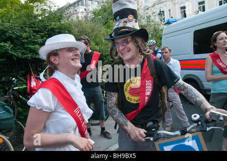 Maschio e femmina Rush clima 'suffragettes' all'inizio di Westminster il potere di pedale bike Rush contro le centrali a carbone Foto Stock