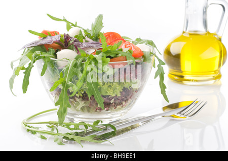 Fresco verde insalata di verdure con mozzarella in una ciotola trasparente su sfondo bianco Foto Stock