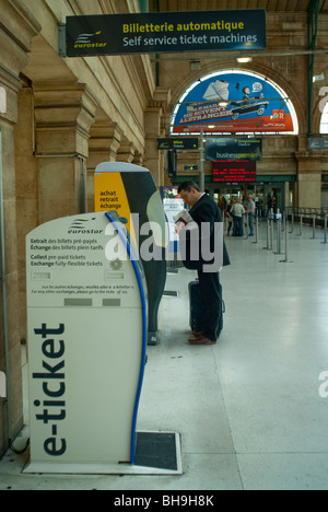 Parigi, Francia- all'interno di 'Gare du Nord' stazione ferroviaria, imprenditore automatica di acquisto i biglietti del treno dal distributore automatico per Eurostar Foto Stock