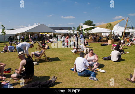 Persone e rilassante la refrigerazione sat sull'erba al di fuori nel sole a Hay Festival 2009. Foto Stock