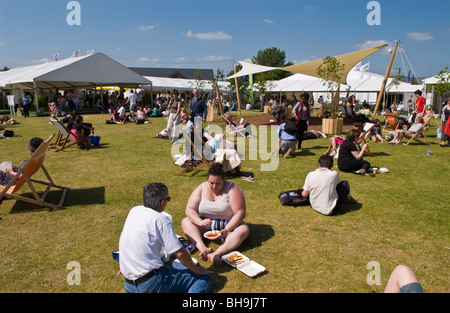 Persone e rilassante la refrigerazione sat sull'erba al di fuori nel sole a Hay Festival 2009. Foto Stock