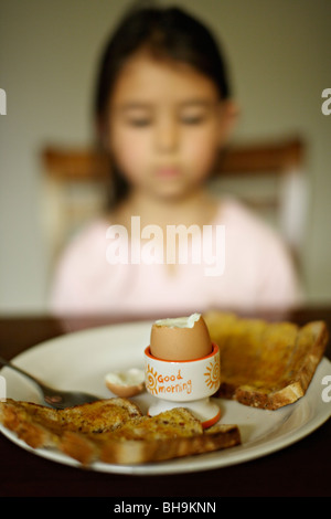 6 anno vecchia ragazza ha bollito uovo per la prima colazione Foto Stock