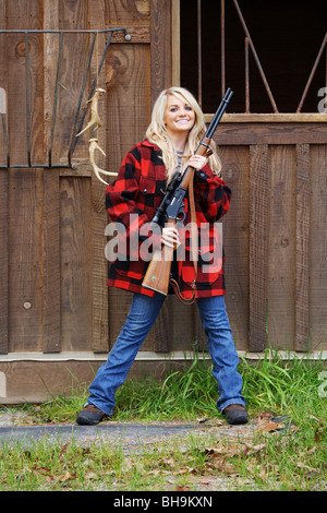 Giovane donna 21 Y.O. Il cacciatore femmina HOLDING MARLIN 30-30 fucile calibro nella parte anteriore del granaio Foto Stock