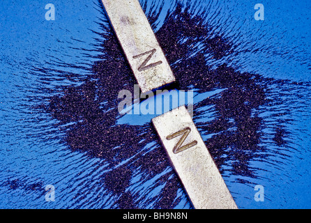 La limatura di ferro mostrano i campi contrapposti di poli uguali di due magneti bar. Nota che i poli simili si respingono. Foto Stock