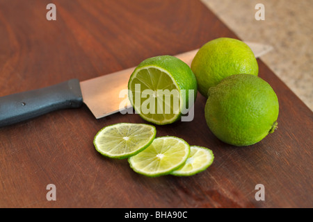 Il taglio di Limette fresche su di un tagliere Foto Stock