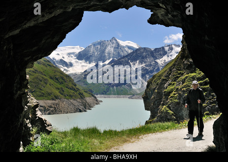 Passeggiate turistiche attraverso la grotta lungo il Lac des Dix, formato dalla grande diga di Dixence in Valais / Wallis, alpi svizzere, Svizzera Foto Stock