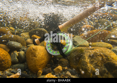 Vista subacquea di una canna da mosca e la bobina in rapido movimento di acqua Montana Creek, Alaska Foto Stock